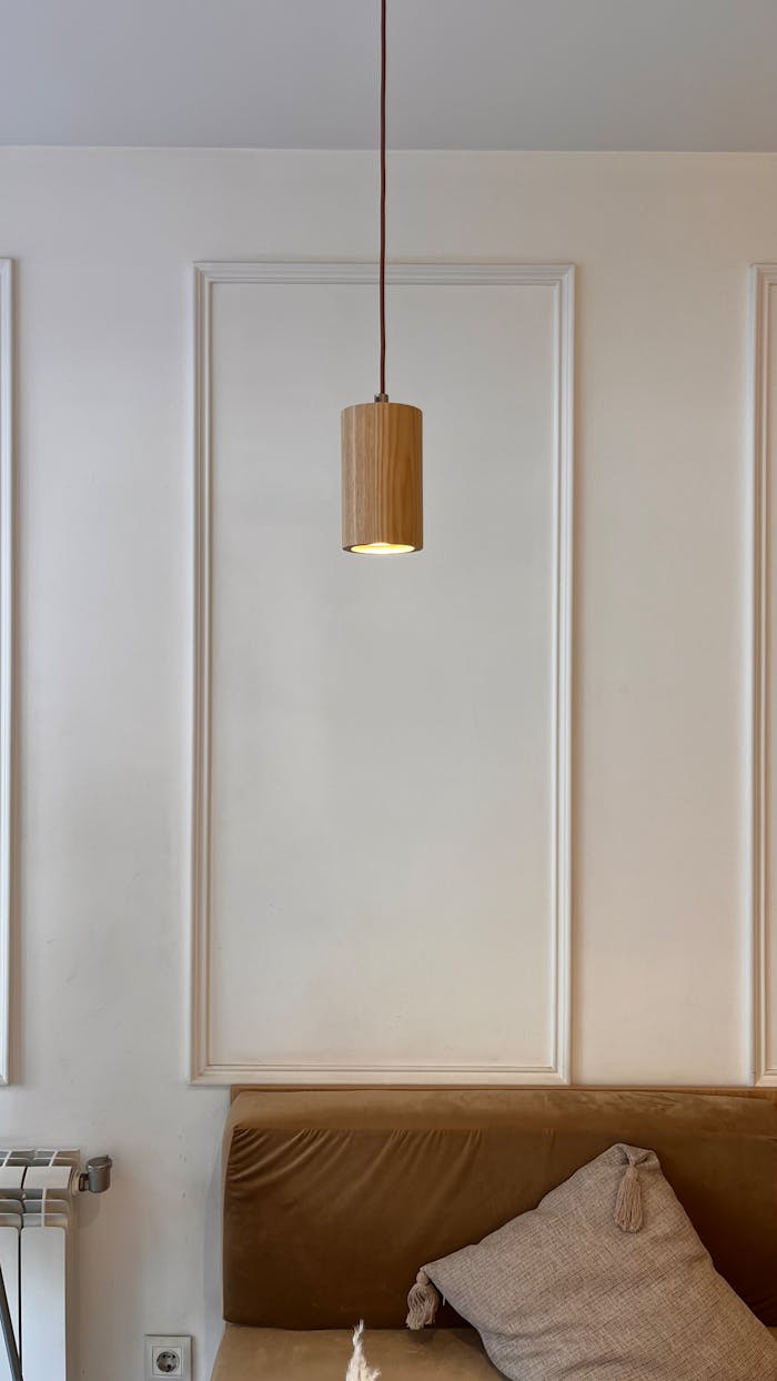why-choose-us-img Elegant minimalist interior showcasing a wooden pendant light above a cozy sofa.